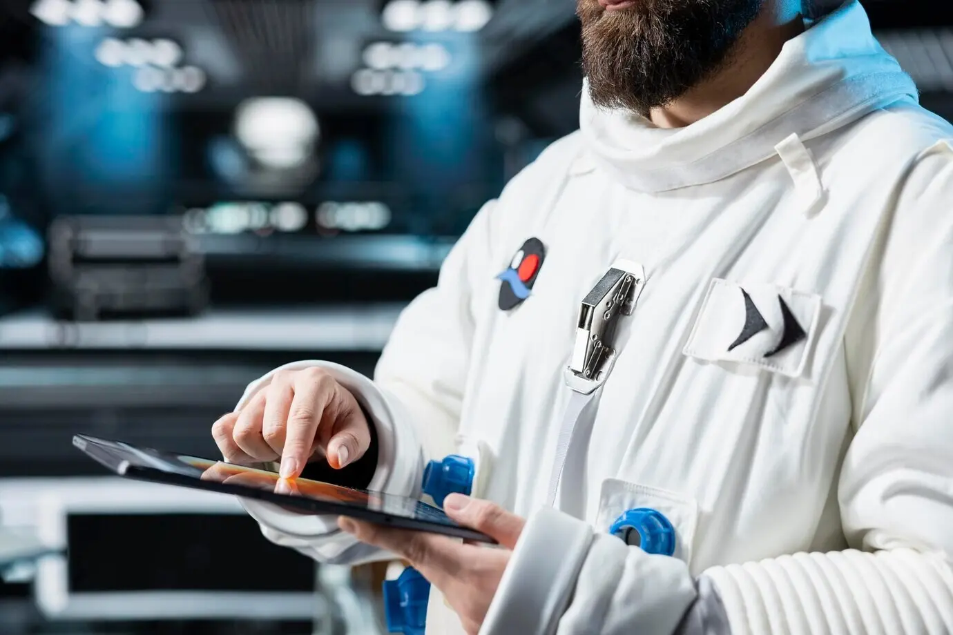 Крупный план астронавта, использующего телеметрическое ПО на планшете.